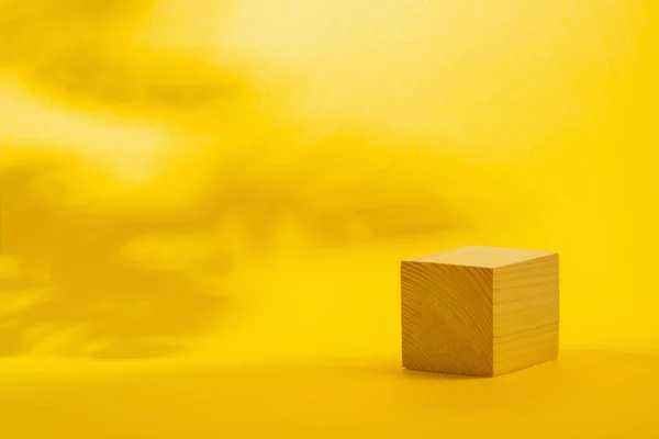 Holzpodiumskubus Auf Leuchtend Gelbem Hintergrund — Stockfoto