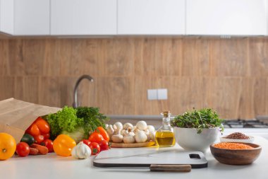 Mutfaktaki beyaz masada taze sağlıklı vejetaryen yemeği.