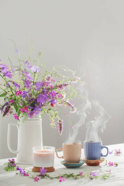 白い木のテーブルの上に夏の野生の花とハーブティー — ストック写真