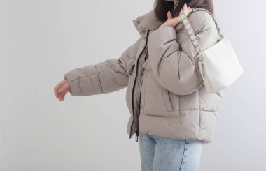 Beyaz arka planda ceketli genç bir kadın.