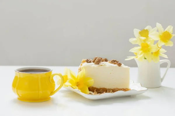Sernik Filiżanką Herbaty Żółte Wiosenne Kwiaty Białym Stole — Zdjęcie stockowe