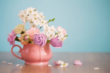 Güzel bahar çiçekleri eski bardaklarda pastel renklerde mavi arka planda