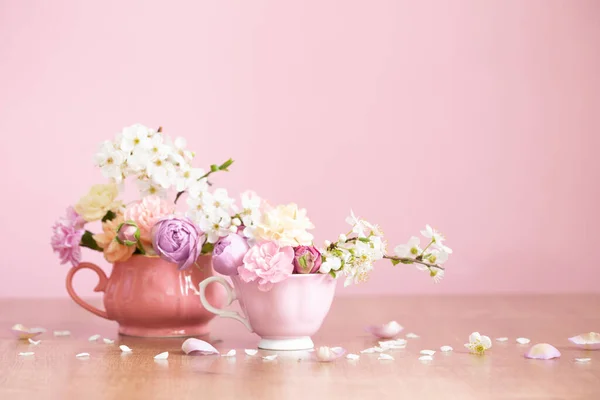 Piękne Wiosenne Kwiaty Dwóch Zabytkowych Filiżanek Różowym Tle — Zdjęcie stockowe