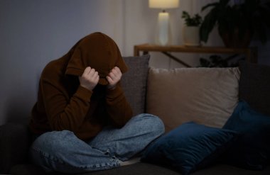 Üzgün genç kız geceleri kanepede oturuyor.