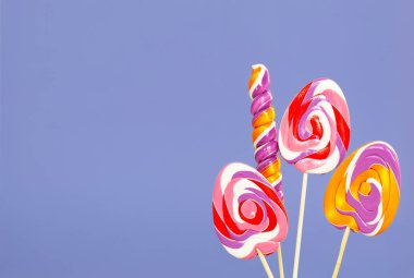Paskalya şeker kamışları mor arka planda yumurta şeklinde.