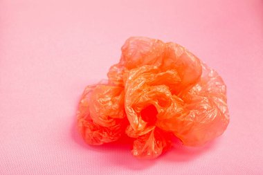 Pembe arka planda turuncu plastik çanta