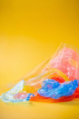 Parlak sarı arkaplanda plastik çöp