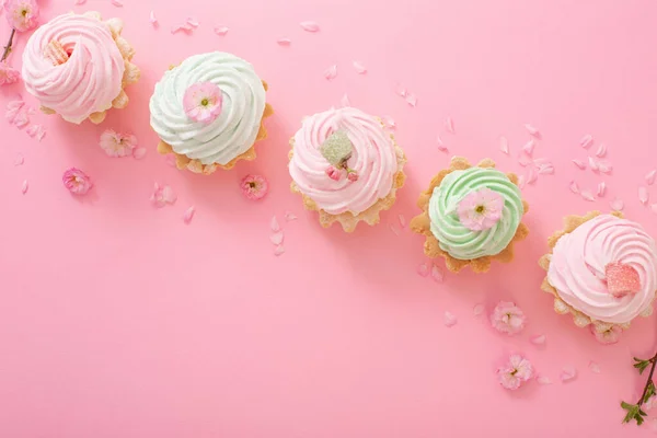 Rosa Und Grüne Cupcakes Mit Frühlingsblumen Auf Rosa Hintergrund — Stockfoto