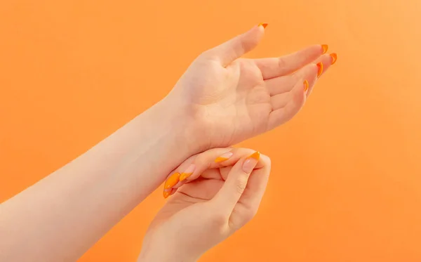 Vrouwelijke Hand Met Manicure Oranje Achtergrond — Stockfoto