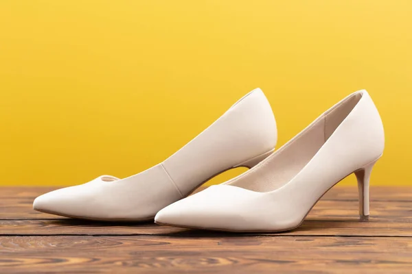 stock image beige shoes on wooden floor on yellow background