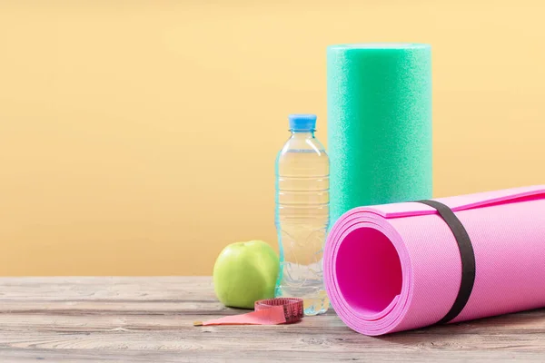 pink fitness mat on wooden floor, concept of health and sport