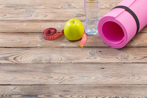 木製の床にピンクのフィットネスマット健康とスポーツの概念 — ストック写真