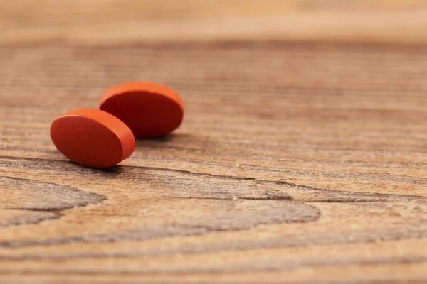 two pills on old wooden background