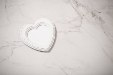 Tahta çerçeve beyaz mermer zemin üzerinde kalp şeklinde