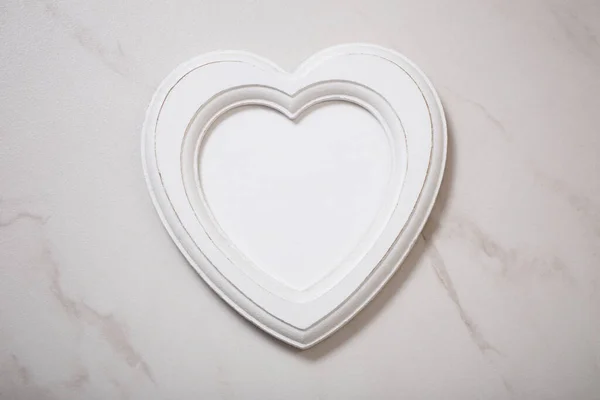 stock image wooden frame in form heart on white marble background