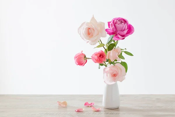 白色背景的白色陶瓷花瓶中的粉红和白玫瑰 — 图库照片