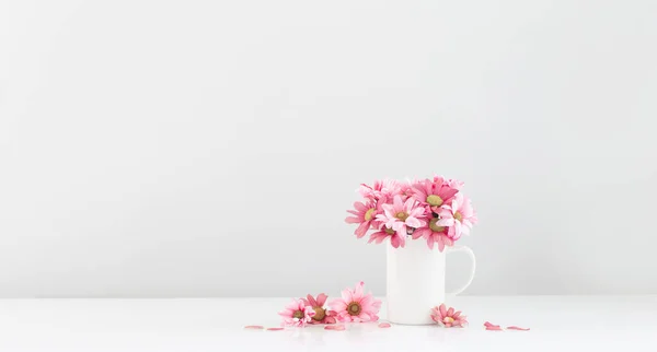 白い背景の白いカップのピンクの菊 — ストック写真