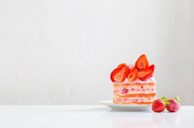 Beyaz masada pembe çilekli pasta.