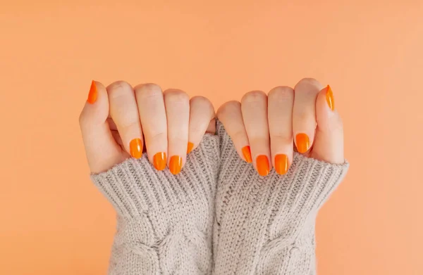 Kobiece Dłonie Pomarańczowym Manicure Pomarańczowym Tle — Zdjęcie stockowe