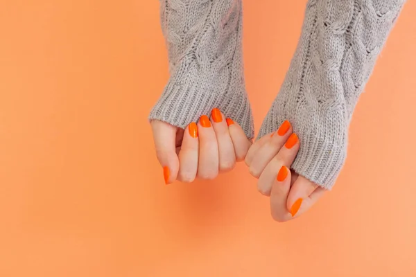 Vrouwelijke Handen Met Oranje Manicure Oranje Achtergrond — Stockfoto