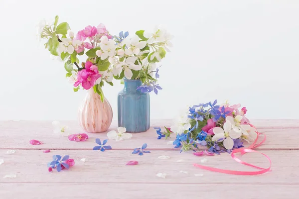 木のテーブルの上にピンクと青の春の花 — ストック写真