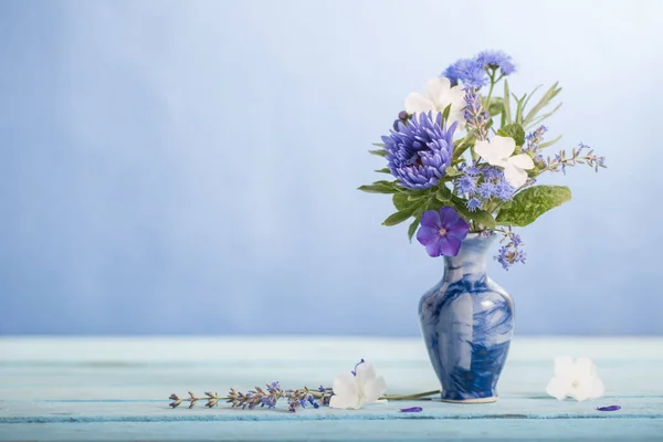 蓝色底色蓝色花瓶中的夏花 — 图库照片