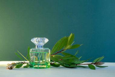 Yeşil arka planda bitkileri olan parfüm şişesi