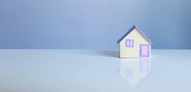 Mavi arka planda küçük kağıt ev