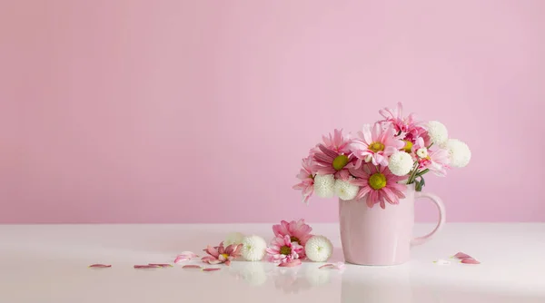 ピンク色のカップに白とピンクの菊 — ストック写真