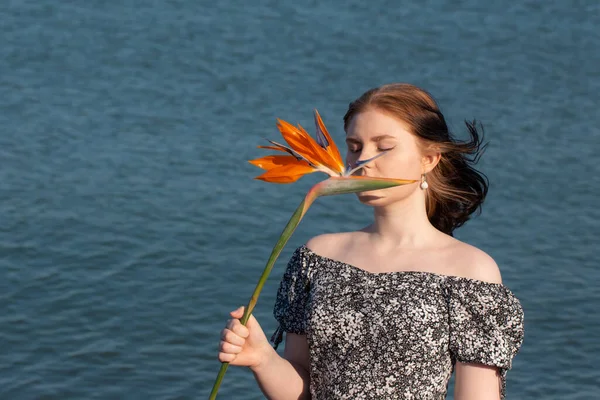 Mladá Žena Oranžovou Exotickou Květinou Pozadí Moře — Stock fotografie