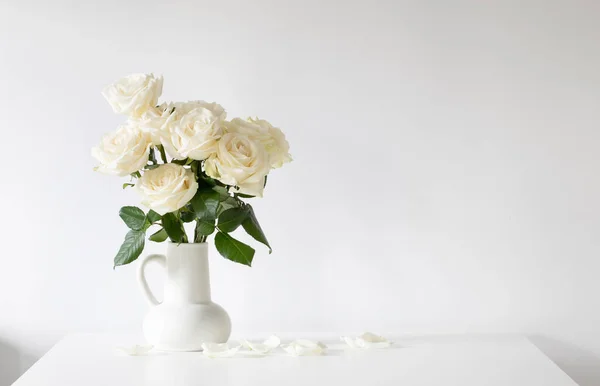 白色背景的水壶中的一束白玫瑰 — 图库照片