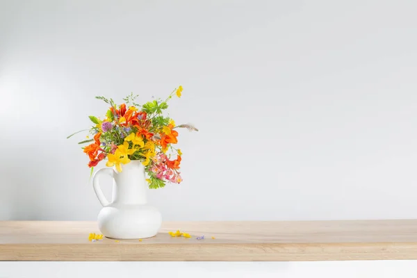 在木制桌子上的白色水壶中的夏天花朵 — 图库照片