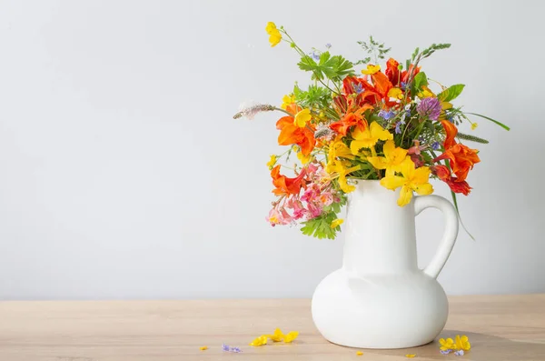 在木制桌子上的白色水壶中的夏天花朵 — 图库照片