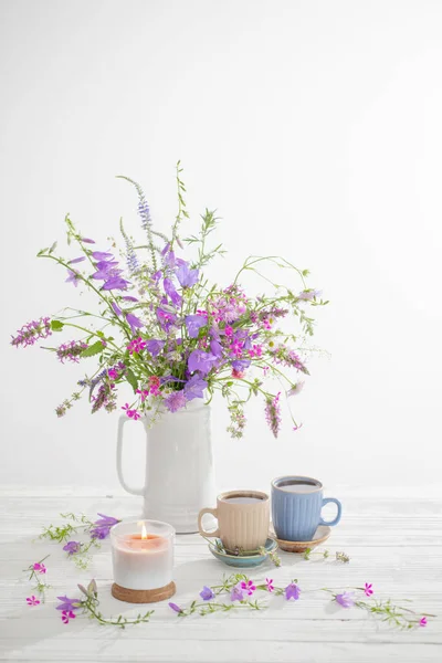 白い木のテーブルの上に夏の野生の花とハーブティー — ストック写真