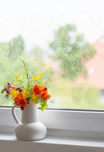 在窗台上的白色水壶中的夏天花朵 — 图库照片