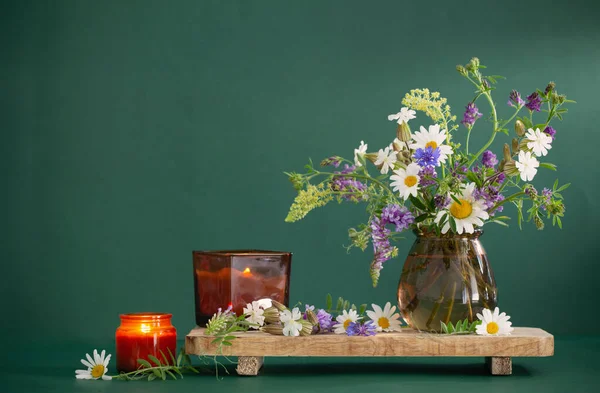 Wilde Bloemen Glas Bruine Vaas Met Brandende Kaarsen Groene Achtergrond — Stockfoto