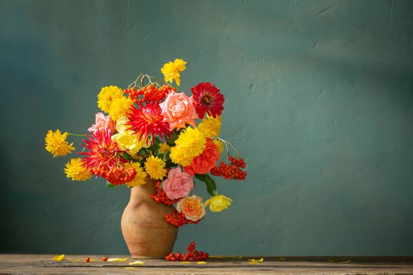 Czerwone Żółte Kwiaty Dzbanku Świetle Słonecznym Tle Ciemnej Ściany — Zdjęcie stockowe