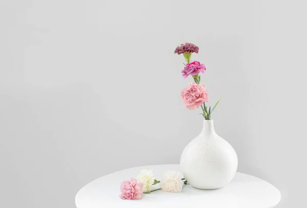 Piękne Goździki Kwiaty Ceramicznym Wazonie Białym Stole — Zdjęcie stockowe