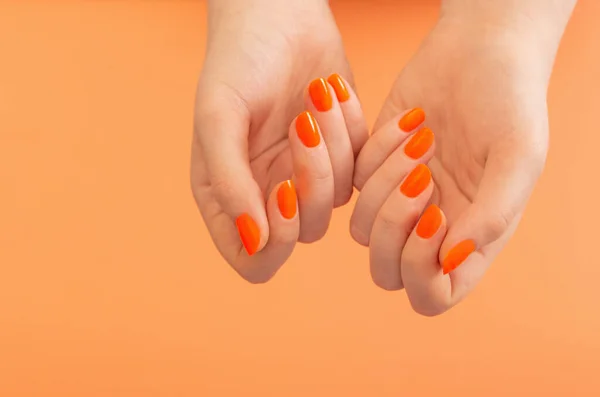 Mains Féminines Avec Manucure Orange Sur Fond Orange — Photo