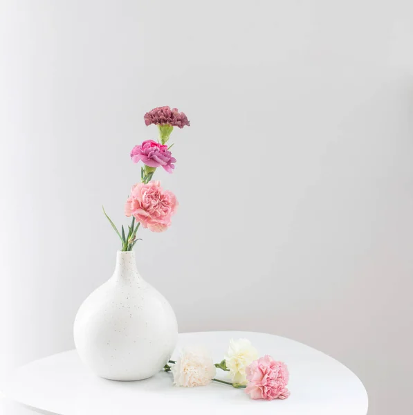 Piękne Goździki Kwiaty Ceramicznym Wazonie Białym Stole — Zdjęcie stockowe