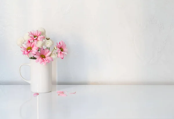白とピンクの菊のヴィンテージカップに白の背景 — ストック写真