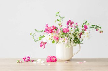 Seramik bardakta yaz çiçekleri açık arkaplanda