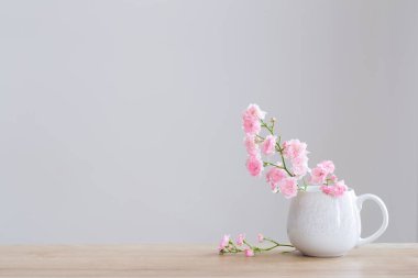 Beyaz arkaplanda seramik bardakta pembe pozlar