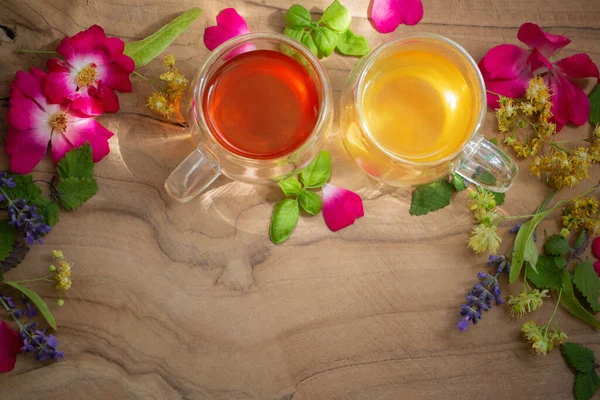 玻璃杯中的香草茶 带有花和木制背景的香草 — 图库照片