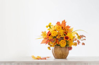 Beyaz arkaplanda seramik vazoda sonbahar buketi