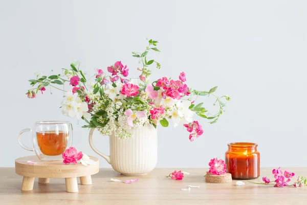 夏天的花朵 燃烧的蜡烛和浅色背景下的茶 — 图库照片