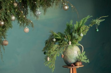 Yeşil arka planda seramik bağbozumu sürahisinde sonsuza dek yeşil dallar