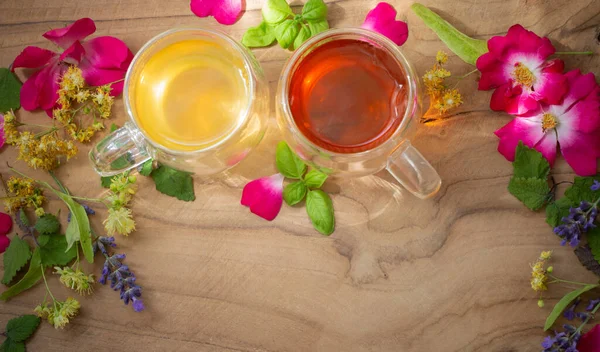 玻璃杯中的香草茶 带有花和木制背景的香草 — 图库照片
