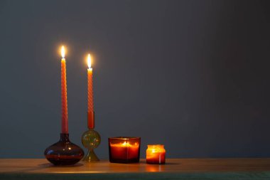 Koyu arkaplanda cam şamdanlarda mum yakmak