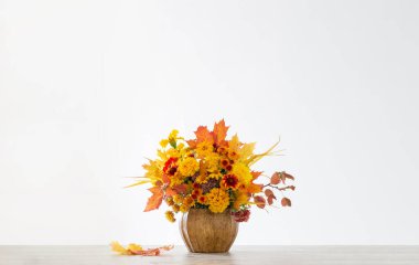 Beyaz arkaplanda seramik vazoda sonbahar buketi